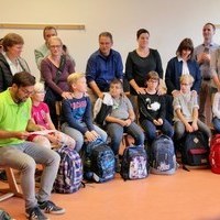 Die Eltern stehen schtzend hinter ihren Kindern