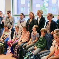 Die Eltern stehen schtzend hinter ihren Kindern